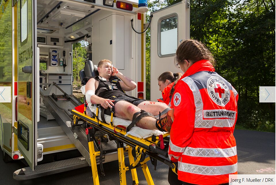 Verletzter Mann auf Trage wird von zwei Rettungskräften in Rettungswagen geschoben.