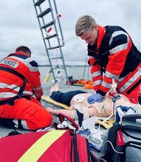 Rettungssanitäter führen eine Simulation mit einem Übungspuppen durch.